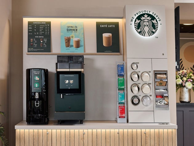 Une station de machines à café libre-service We Proudly Serve Starbucks