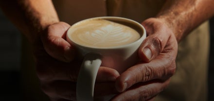 Gros plan sur des mains tenant une tasse de café Starbucks